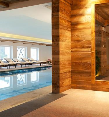 Large indoor pool with loungers at the Wellnesshotel Watles in the upper Vinschgau Valley